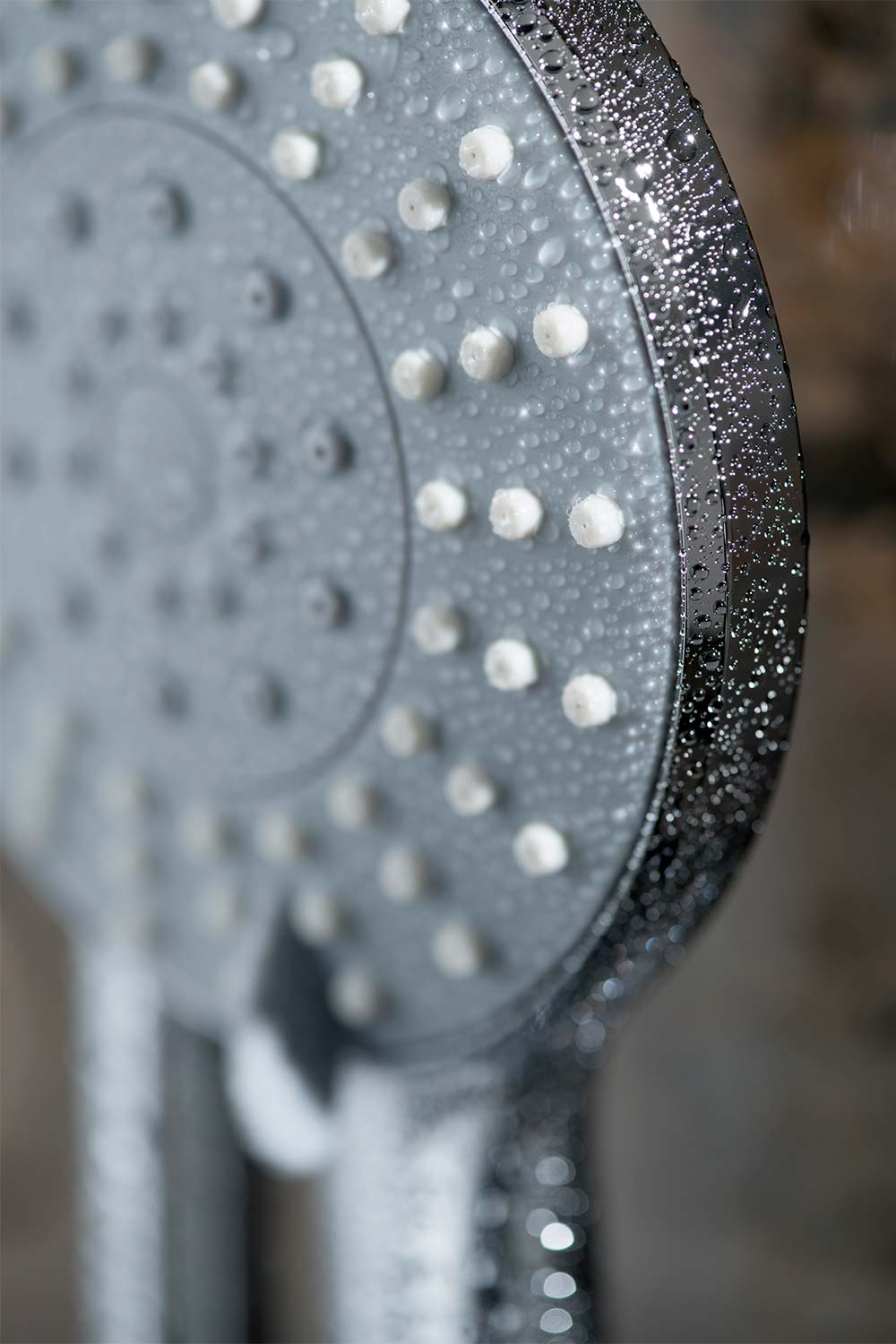 Close up macro photography of a chrome shower head with water drops