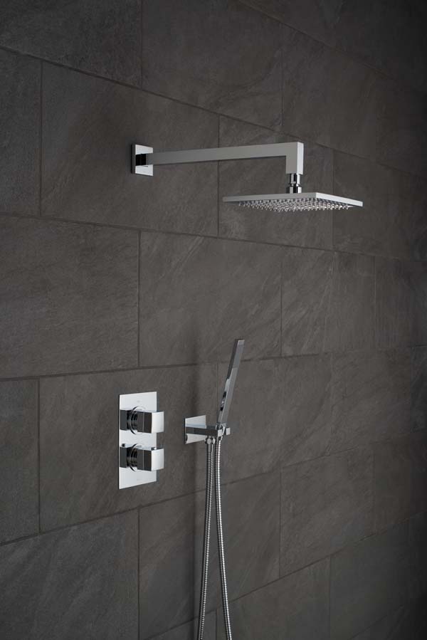 Modern square and rectangular shower head and arm, wall mounted shower kit and concealed thermostatic shower valve on a black slate tiled wall.