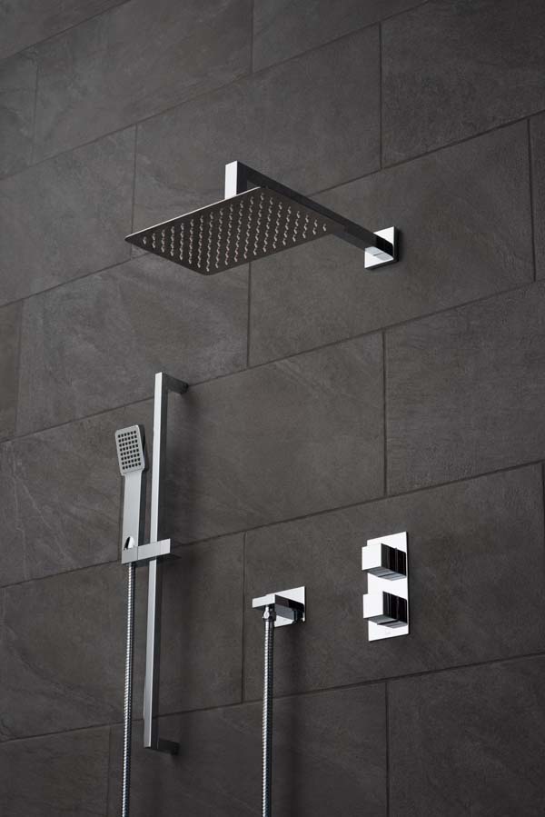 Modern rectangular shower head and arm, wall mounted shower kit and concealed thermostatic shower valve on a black slate tiled wall.